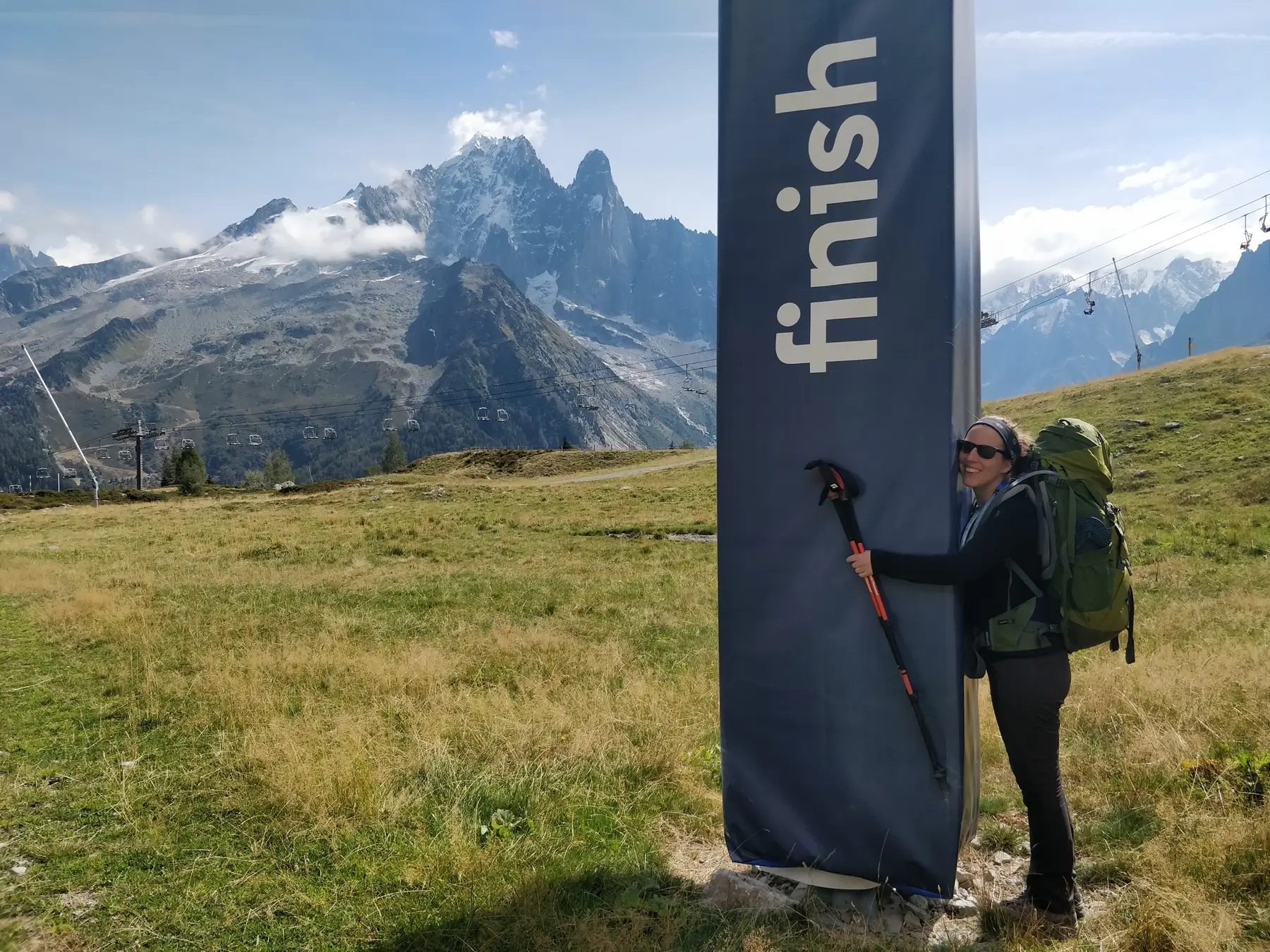 hiker hugging finish sign